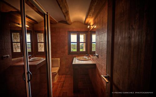 a bathroom with two sinks and a toilet at Castell D´Orpí in Orpí