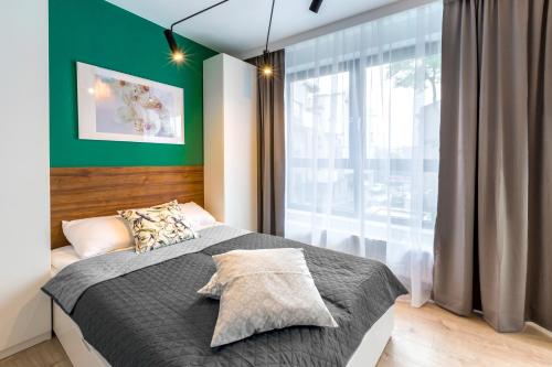 een slaapkamer met een bed en een groot raam bij Friendhouse Apartments Vistula&Wawel in Krakau