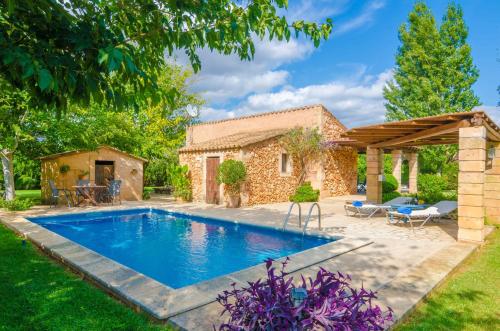 a swimming pool in a yard with a stone house at Ses Tendes in Algaida
