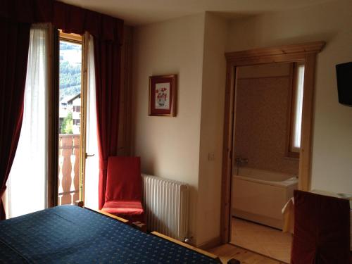 a bedroom with a bed and a bathroom with a tub at Meublè Cima Bianca Garni in Bormio