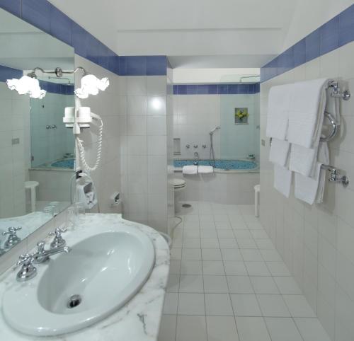 a bathroom with a sink, toilet and bathtub at Hotel Villa Brunella in Capri