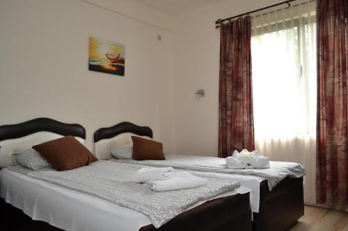 a bedroom with a bed with two towels on it at Guesthouse Vila DND in Niška Banja