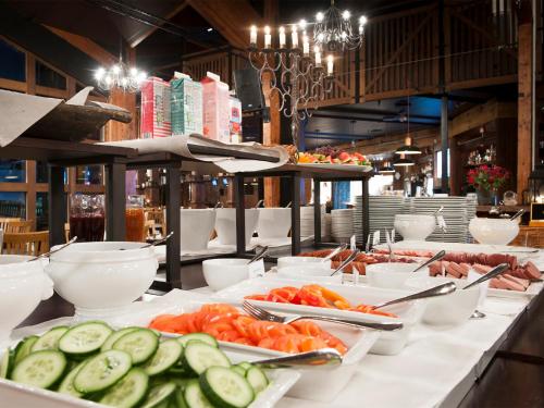 a buffet of food with cucumbers and tomatoes on plates at Stoten Ski Hotel in Stöten