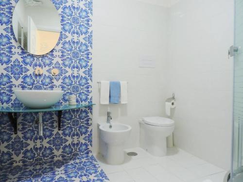 baño azul y blanco con lavabo y aseo en Mediterraneo Rooms, en Palinuro