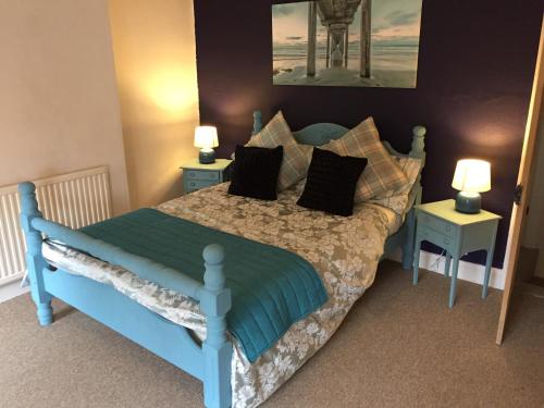 a bedroom with a blue bed with two night stands at City Living in Norwich