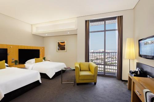 Postel nebo postele na pokoji v ubytování Hala Arjaan by Rotana, Deluxe Hotel Apartments