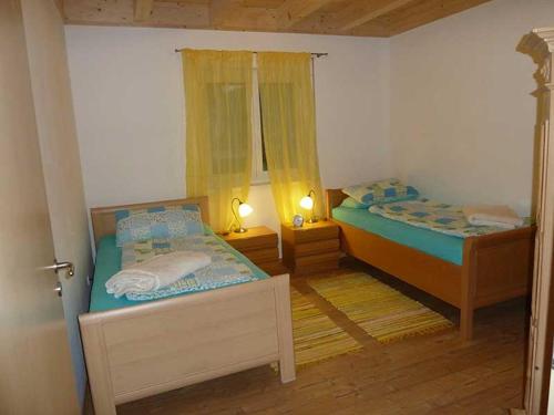 dwa łóżka w małym pokoju z dwoma lampami w obiekcie Ferienhaus Geißdörfer w mieście Hunding