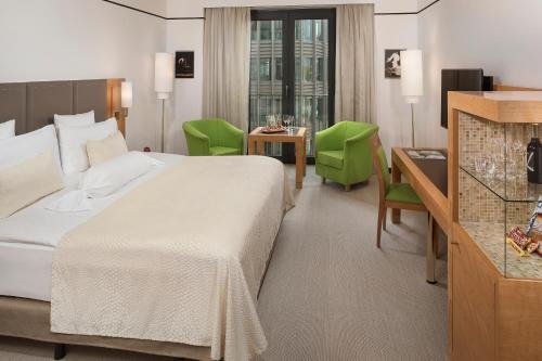 a hotel room with a bed and a table and chairs at Meliá Berlin in Berlin