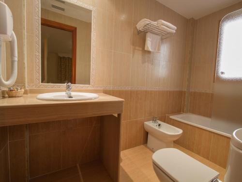 a bathroom with a sink and a toilet and a mirror at La Higuera in Güéjar-Sierra