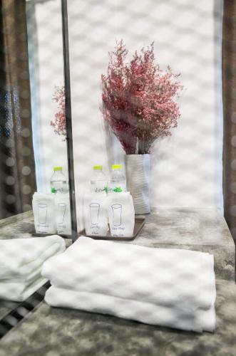 a pile of towels sitting on a table with a vase at Pimchanok Resort in Phetchaburi