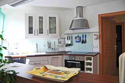 cocina con armarios blancos y encimera en Appartement Sunshine, en Aichtal 