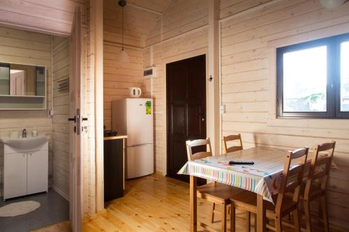 a kitchen with a table with chairs and a refrigerator at U Sasiadow in Mielenko