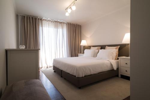 ein Schlafzimmer mit großem Bett und Fenster in der Unterkunft ARTS In Penthouse Apartments Til Sol in Funchal