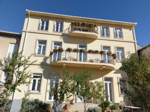 un edificio amarillo con balcones y macetas. en Aurelia Rooms en Mostar