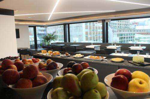 a buffet with bowls of fruit on a table at Hotel U Viveiro in Viveiro