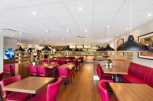 a restaurant with wooden tables and pink chairs at Drive-in Motell in Mjölby