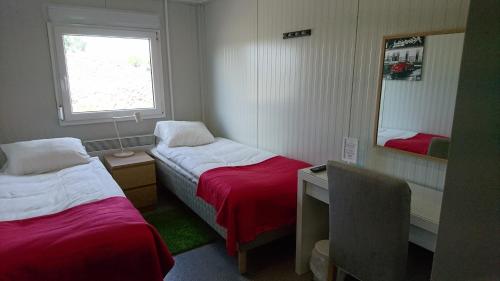 a small room with two beds and a mirror at Drive-in Motell in Mjölby