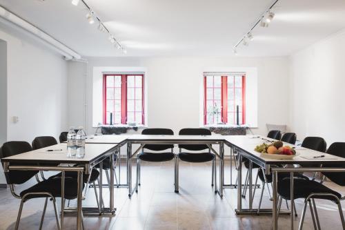 une grande pièce avec des tables, des chaises et des fenêtres dans l'établissement Hotell Breda Blick, à Visby