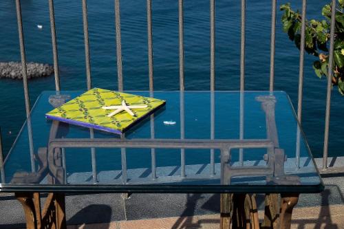 a table with an umbrella sitting on top of a bench at Villa Ketty Resort in Vico Equense