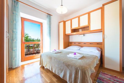 um quarto com uma cama e uma grande janela em Apartment A&T Countryside em Cilipi