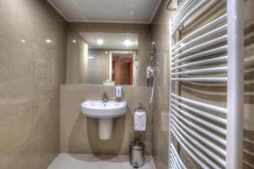 a bathroom with a sink and a mirror at Anna Hotel in Budapest