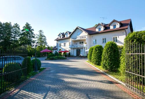 a white house with a fence on a street at Gościniec Kuklówka in Kuklówka