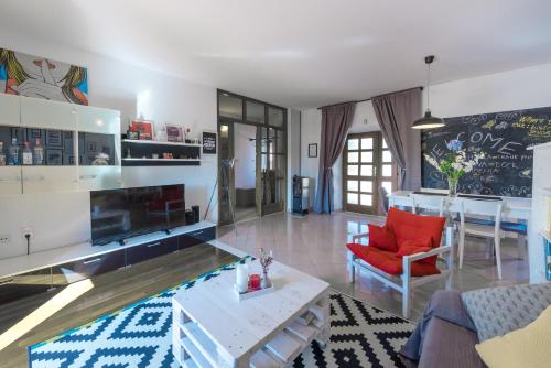 uma sala de estar com uma cadeira vermelha e uma mesa em Apartment A&T Countryside em Cilipi