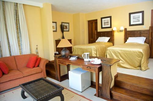 a living room with a couch and two beds at The Great Rift Valley Lodge & Golf Resort in Naivasha