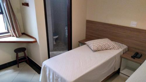 a bedroom with a bed and a glass shower at Hotel Vilamoura in Sao Paulo