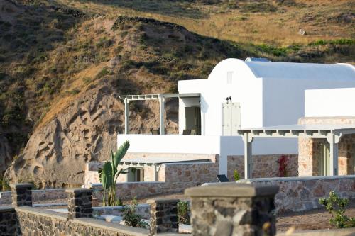 a white chapel with a mountain in the background at Desiterra Resort & Spa in Fira