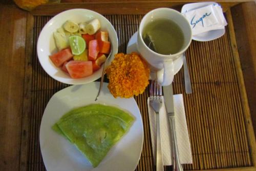 un tavolo con un piatto di cibo e una tazza di caffè di Recep Bungalow ad Ubud
