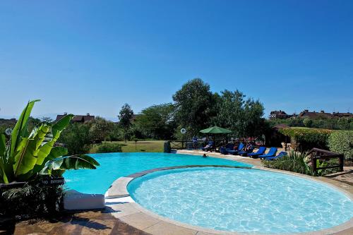 una grande piscina con acqua blu in un cortile di The Great Rift Valley Lodge & Golf Resort a Naivasha