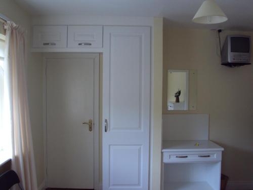 a kitchen with a door and a white cabinet at Ryebrook House in Killarney