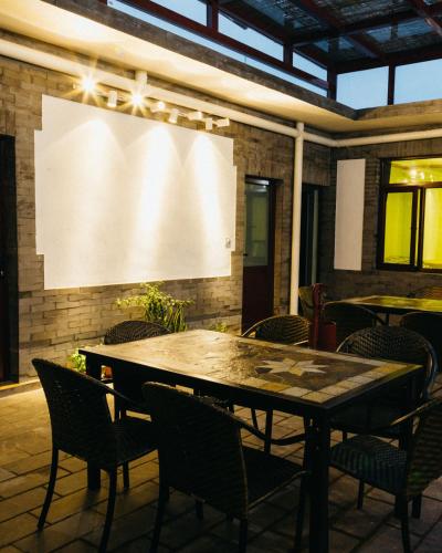 a table and chairs in a room with a projection screen at Chez Ina & Jasee in Miyun