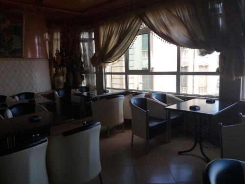 a restaurant with tables and chairs and a window at Hotel Le Gardenia (ex Lutetia) in Tangier