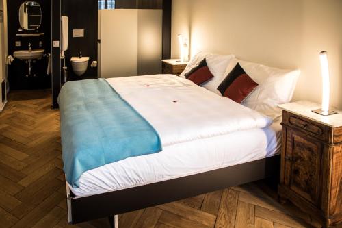 a bedroom with a bed with a blue blanket on it at Kreuz Herzogenbuchsee in Herzogenbuchsee