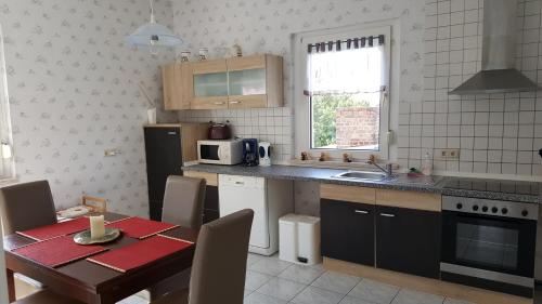 a kitchen with a table and a microwave and a table and chairs at Ferienwohnung Bleicherode in Bleicherode