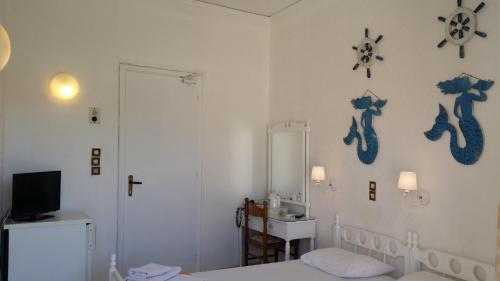 a room with a white wall and a white table at Rachel Hotel in Agia Marina Aegina