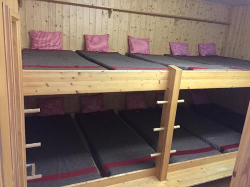 a bunk bed in a cabin with purple pillows at Restaurant Fleschboden in Rosswald