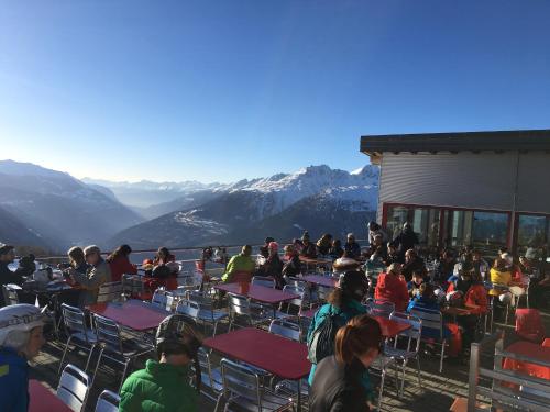 a group of people sitting at tables in front of a building at Restaurant Fleschboden in Rosswald