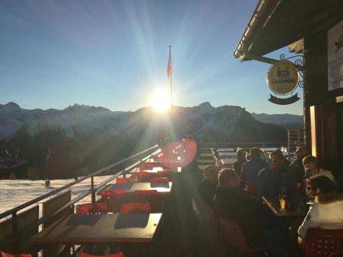 a group of people sitting at tables watching the sun rise at Restaurant Fleschboden in Rosswald