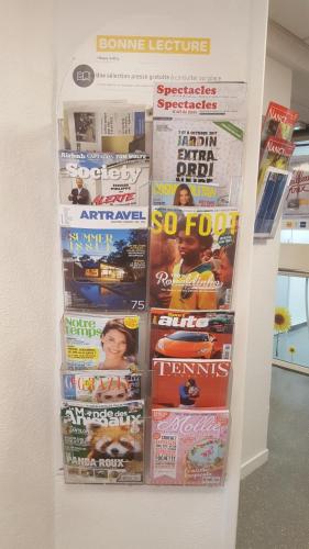 a display of magazines and newspapers on a wall at Premiere Classe Nancy Est Essey in Essey-lès-Nancy