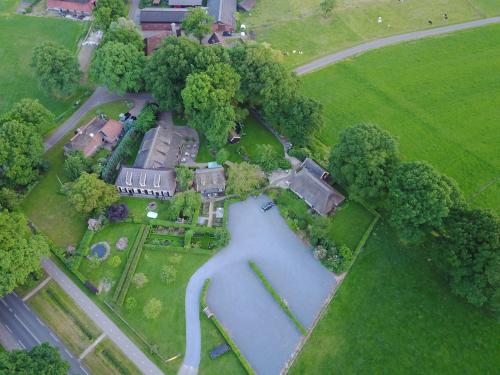 an aerial view of a house with a pond at Pension De Hoestinkhof in Markelo