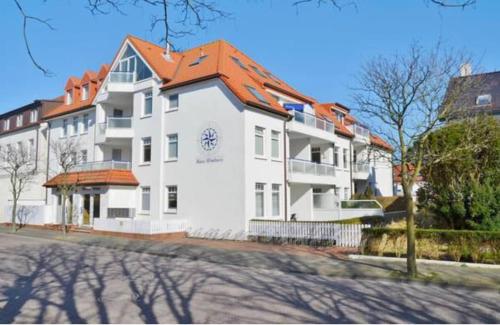 a large white building with an orange roof at Haus Windrose in Norderney