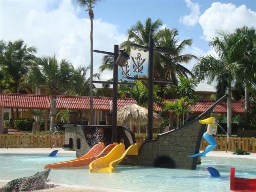 
a man is in the water with a surfboard at Grand Palladium Punta Cana Resort & Spa - All Inclusive in Punta Cana
