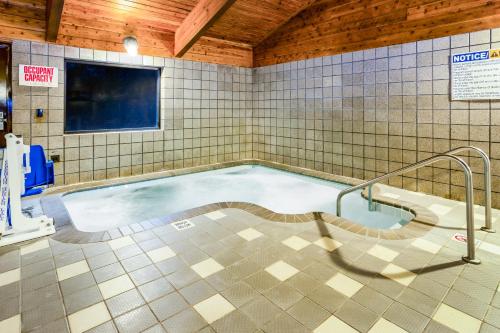a swimming pool in a room with a tv at AmericInn by Wyndham Menomonie in Menomonie