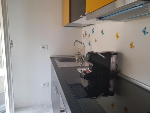 a kitchen with a sink and a counter with butterflies on the wall at BSuites Apartment in Padova