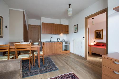a kitchen and dining room with a table and a bed at Chalet Santa Barbara in Bormio