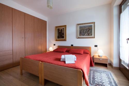 a bedroom with a red bed with two towels on it at Chalet Santa Barbara in Bormio