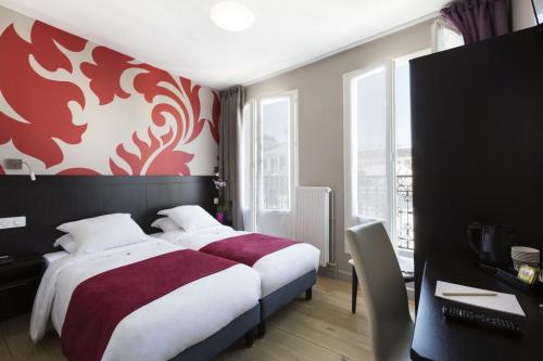 1 dormitorio con 1 cama con pared roja y blanca en Hotel Bastille Secret, en París